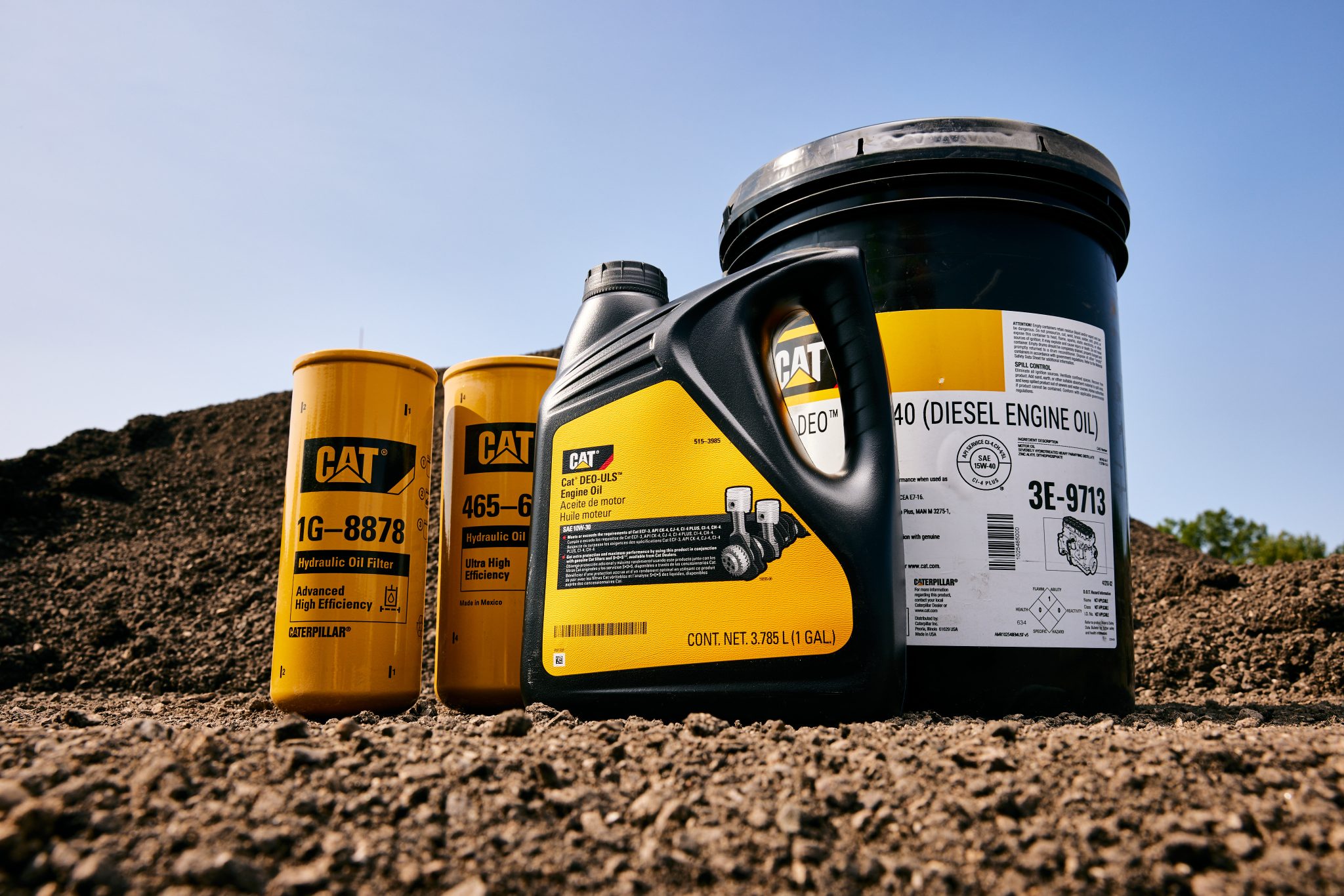 Cat oil filters and diesel engine oil containers on a dirt jobsite
