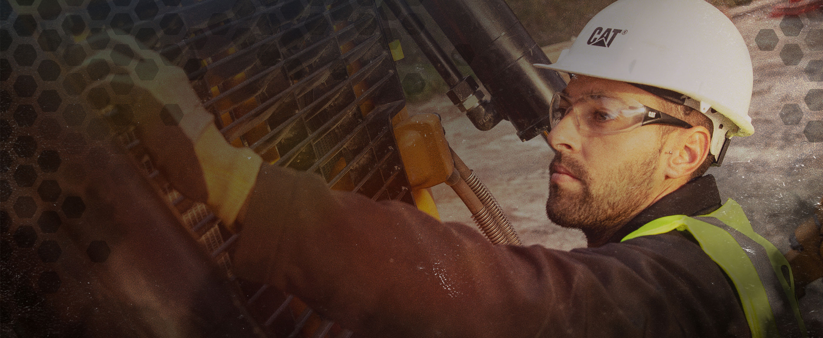 Service technician wearing a hard hat and safety glasses inspects industrial equipment.