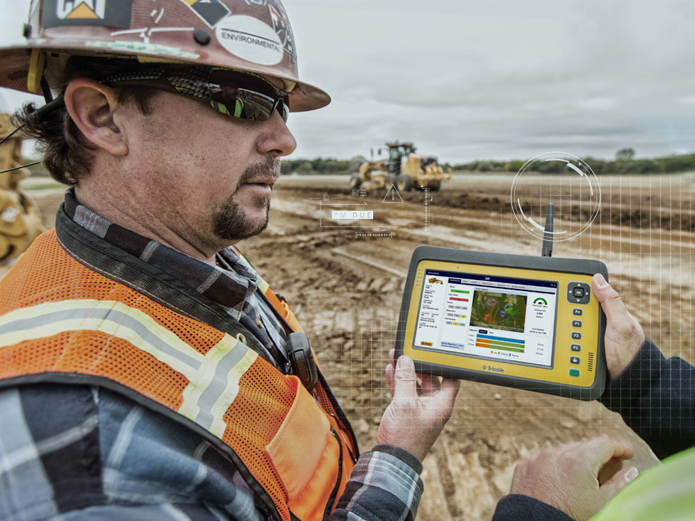 Construction professional reviews jobsite data on a handheld tablet