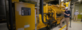 Service advisor inspects a Caterpillar generator set inside an industrial power facility.
